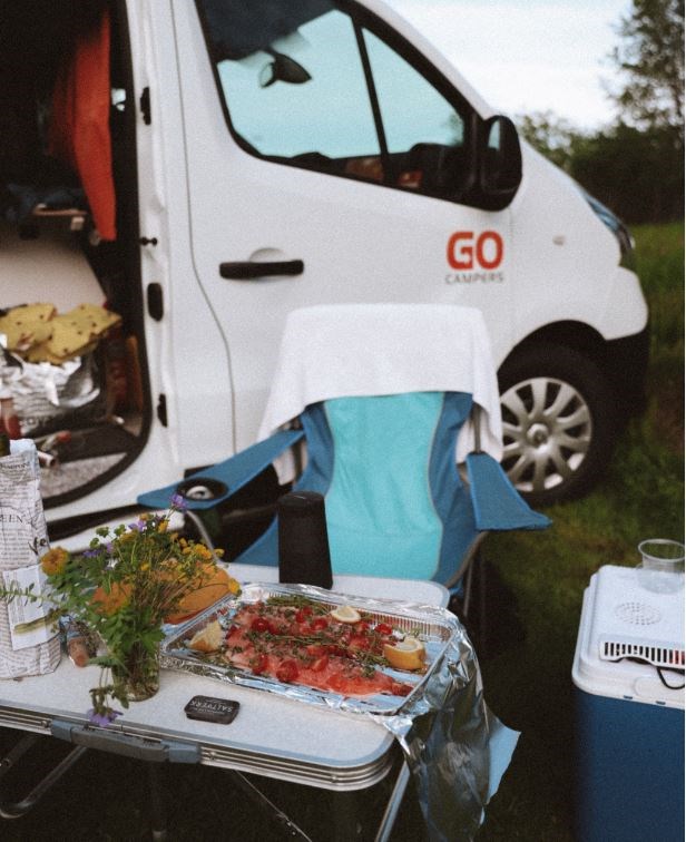 Seat by a campervan with lunch in front
